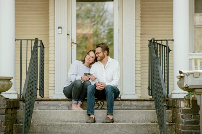 couple sitting on stoop outside of new home